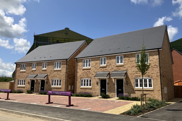 A newly buit development showing four homes with black doors