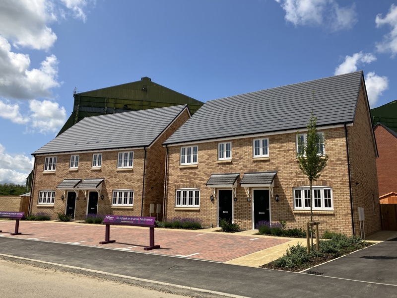 A newly buit development showing four homes with black doors