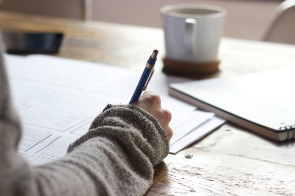 A woman holding a pen filling in forms