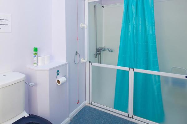 An accessible bathroom with a walk-in shower and a blue shower curtain