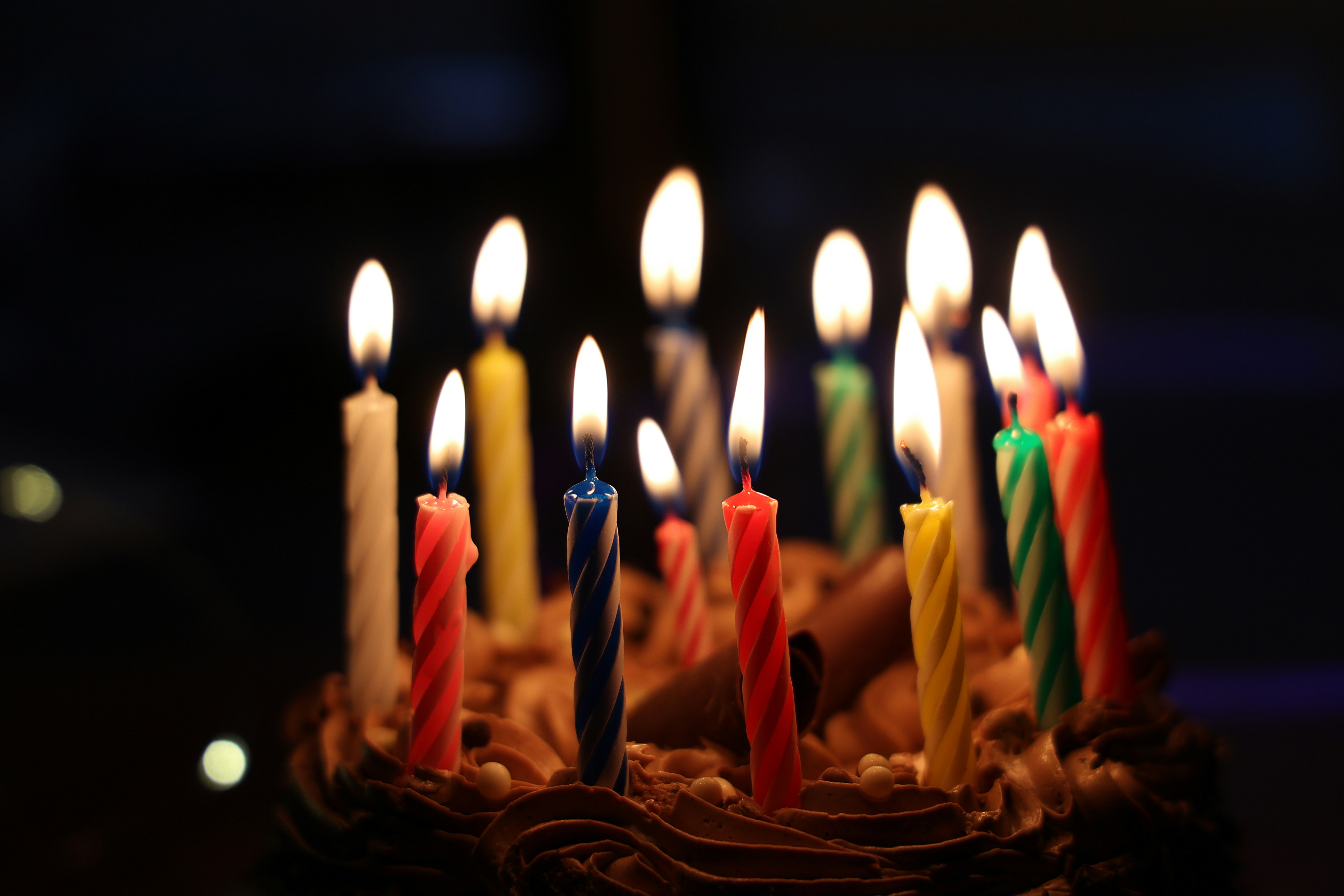 Candles on a birthday cake burning brightly in the darkness