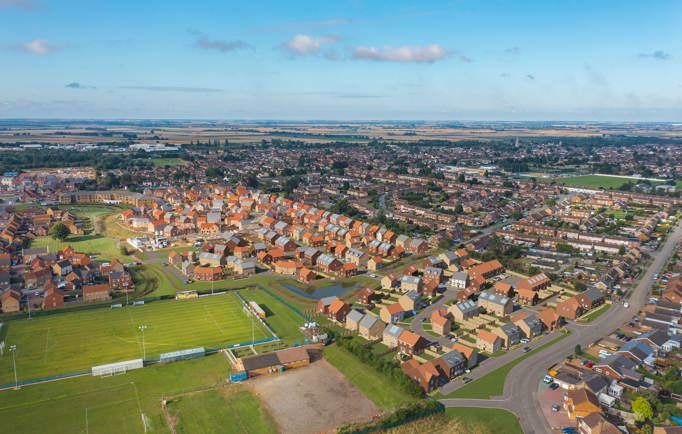 A birds eye view of a thriving town filled with red brick homes