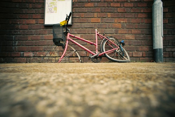 A broken abandoned bicycle with no wheels 