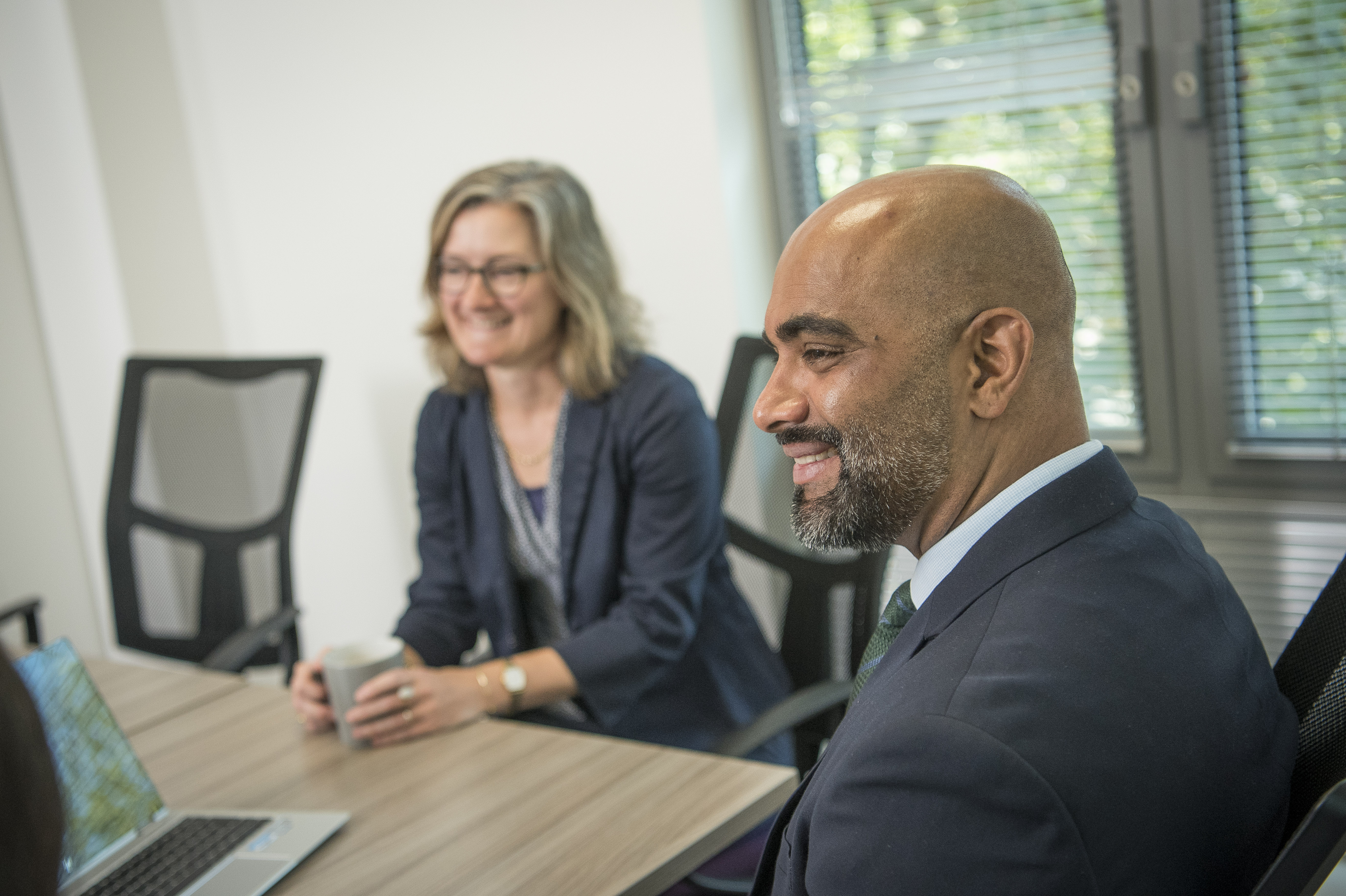 Two Office Workers Smiling In Meeting