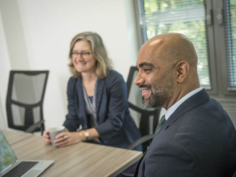 Two Office Workers Smiling In Meeting