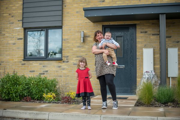 Mum With Two Children Outside Home Smiling