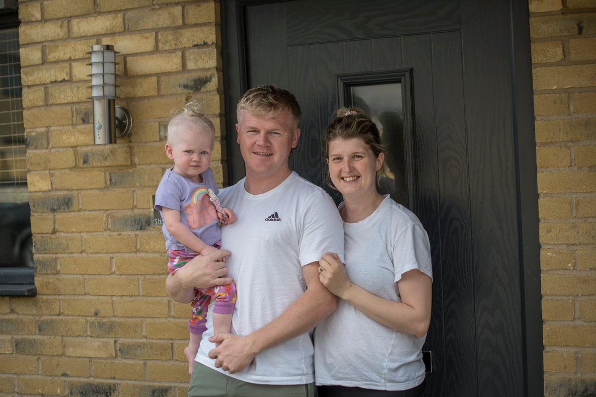 Accent Young Couple Stood Outside Home With Baby