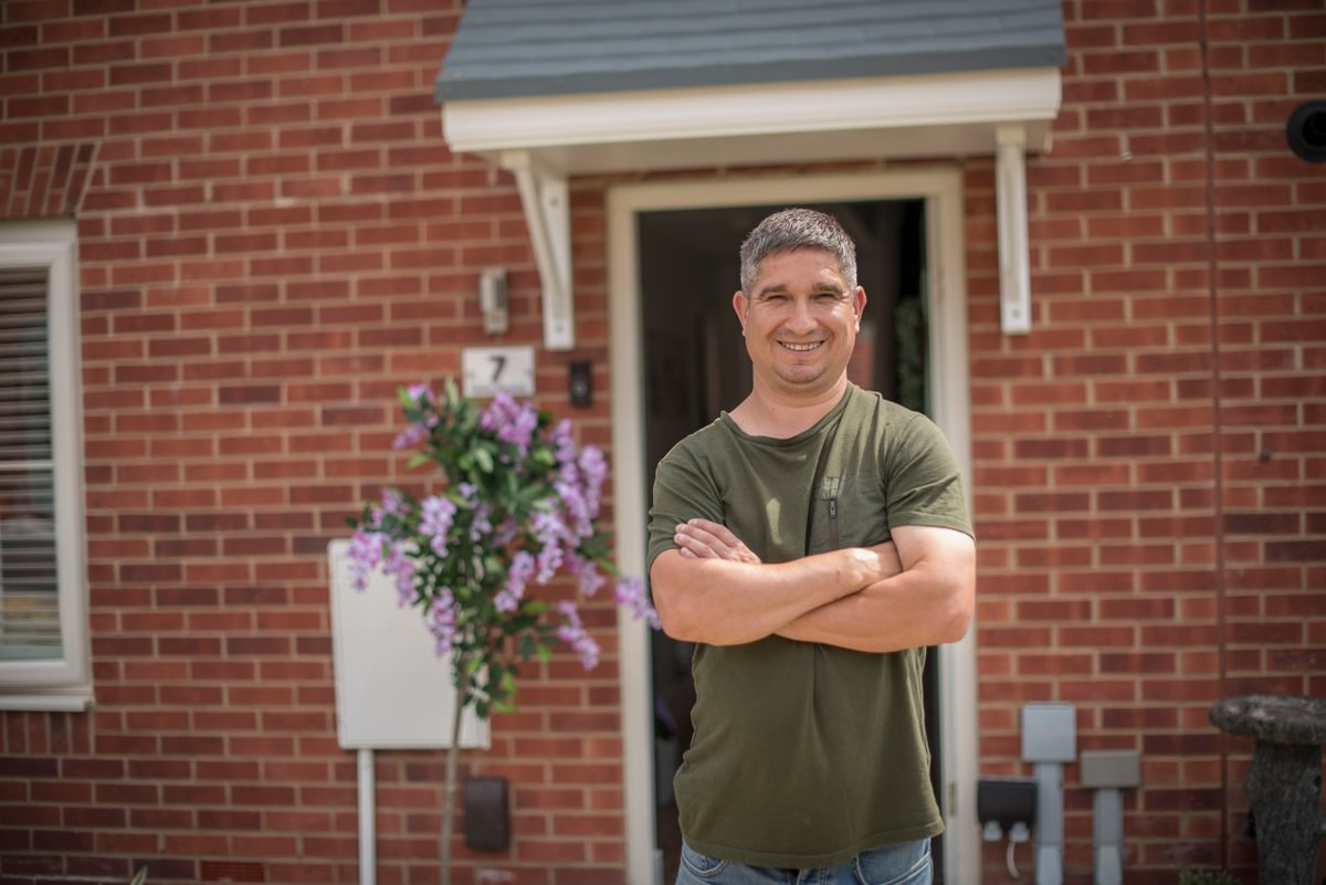 Man In Green Top Stood Outside His House